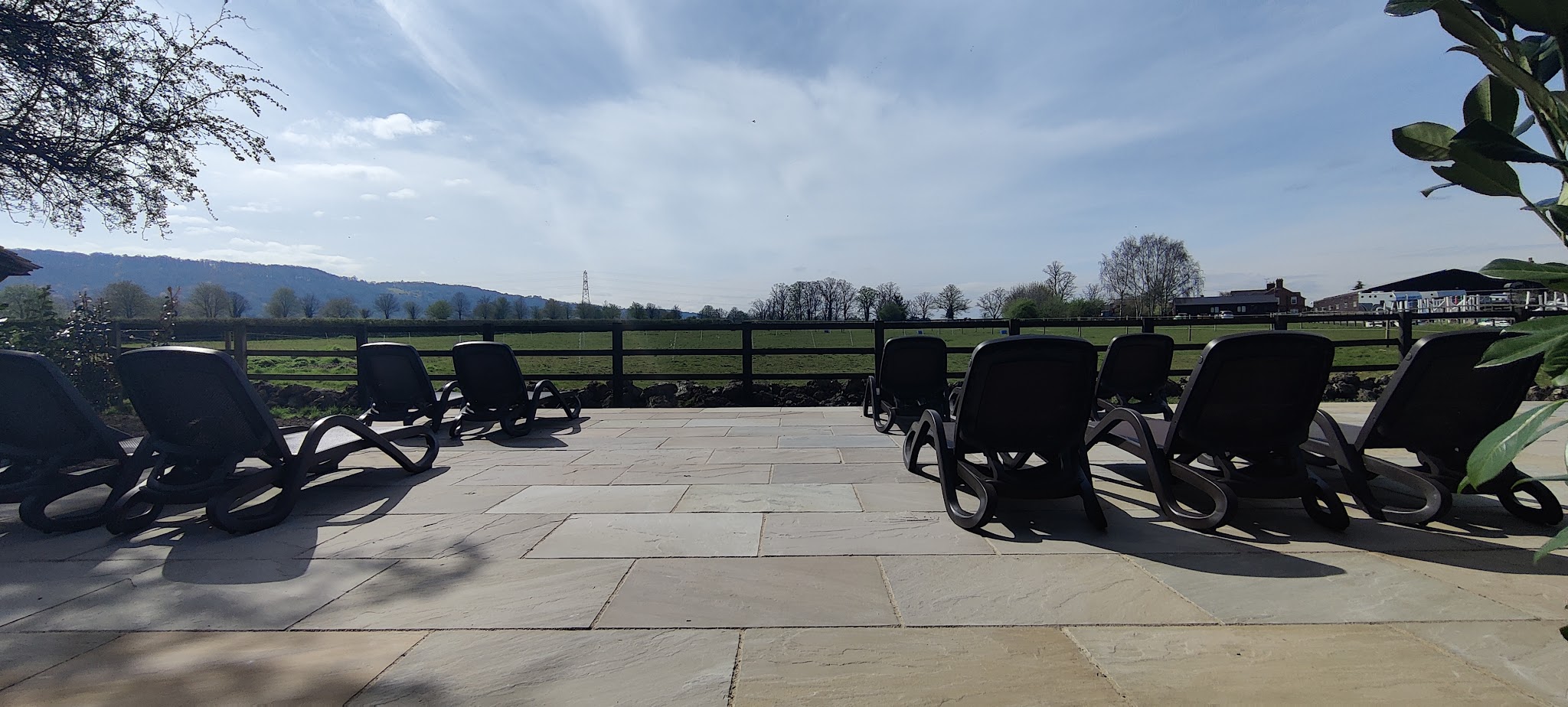 A large sandstone terrace with loungers looking out over the countryside