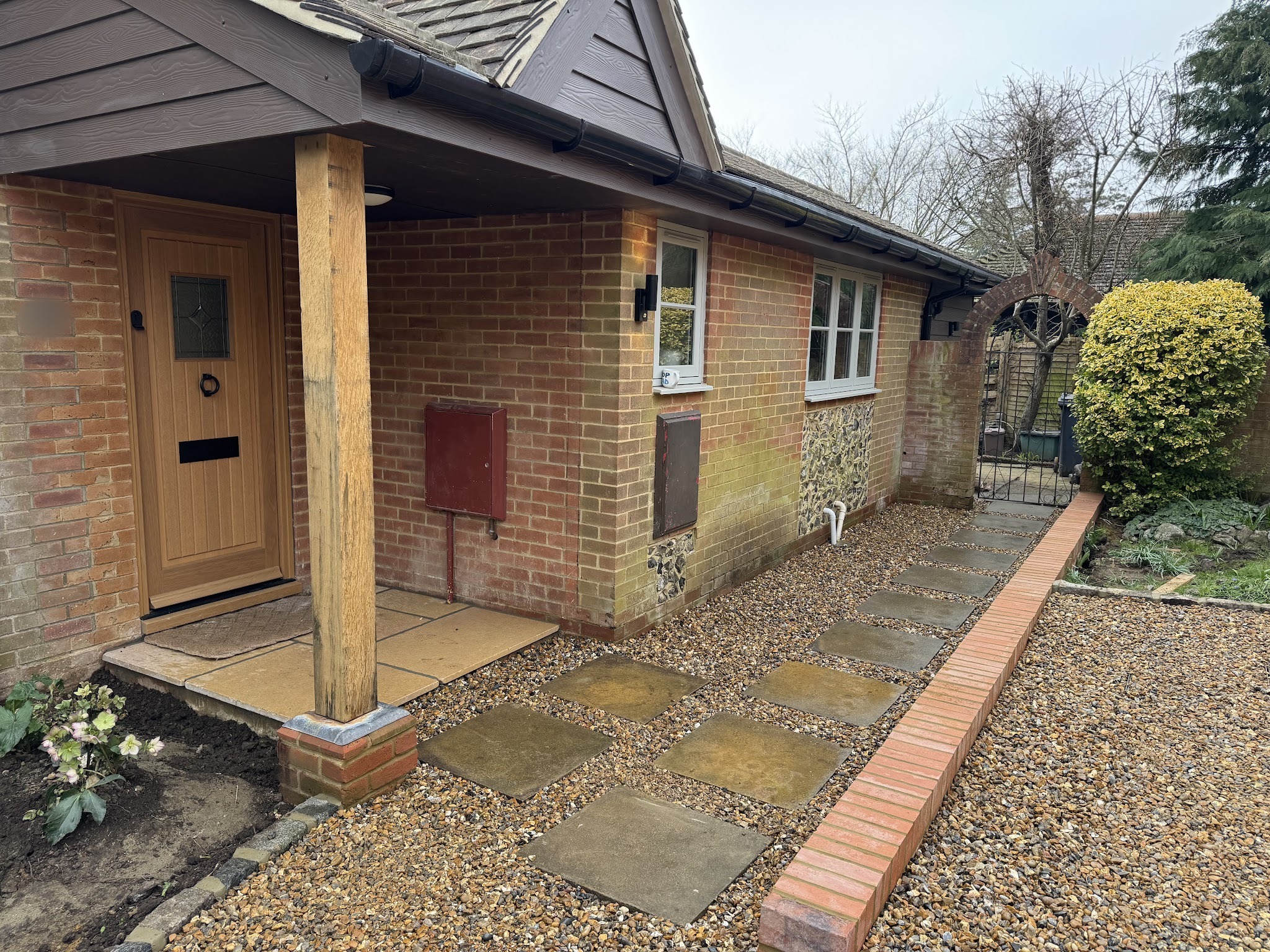 A gravel front garden with stepping slabs and a brick edge by the porch