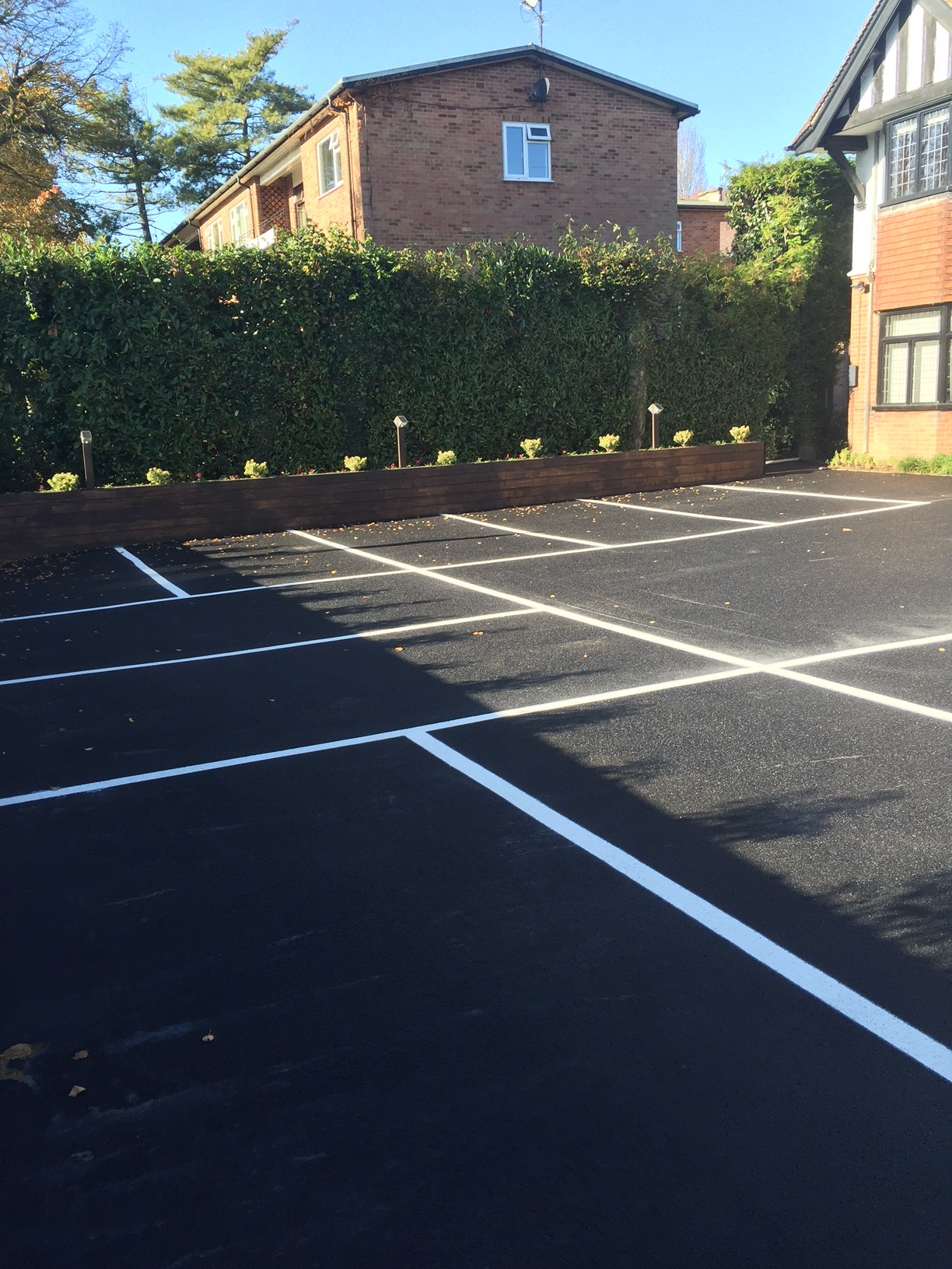 A tarmac car park with fresh white bay lines