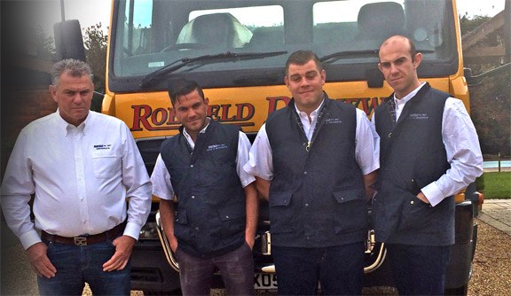 The Roefield team in branded gilets in front of one of our yellow lorries