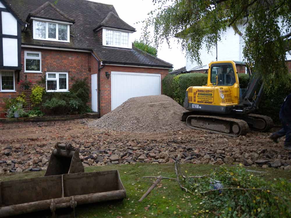 A digger excavating the old drive in front of the house